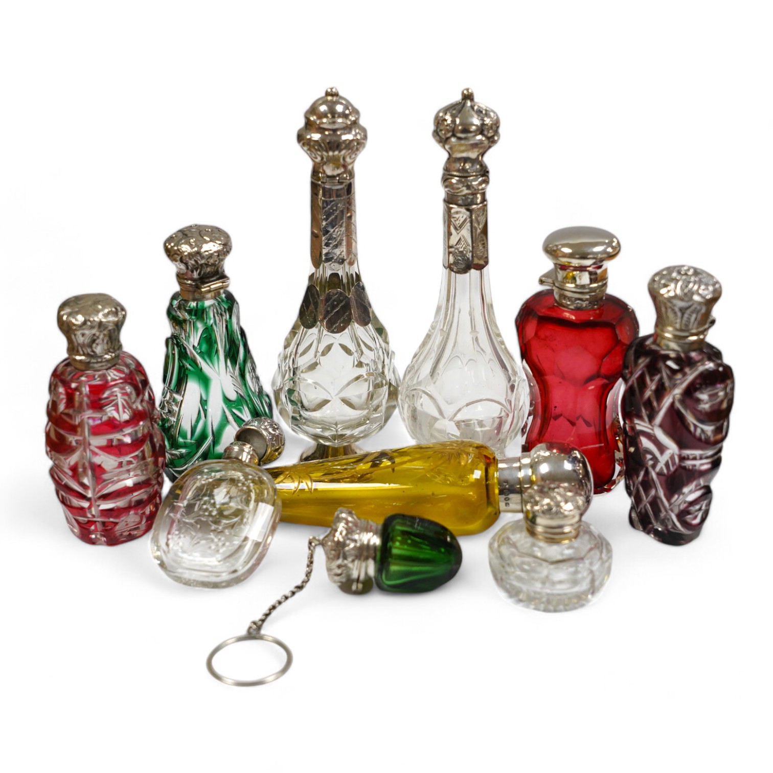 A collection of ten assorted Victorian and later silver or white metal mounted glass scent bottles, including teardrop shaped by Saunders & Shepherd, Birmingham, 1884, 12.7cm. Condition - poor to fair to good